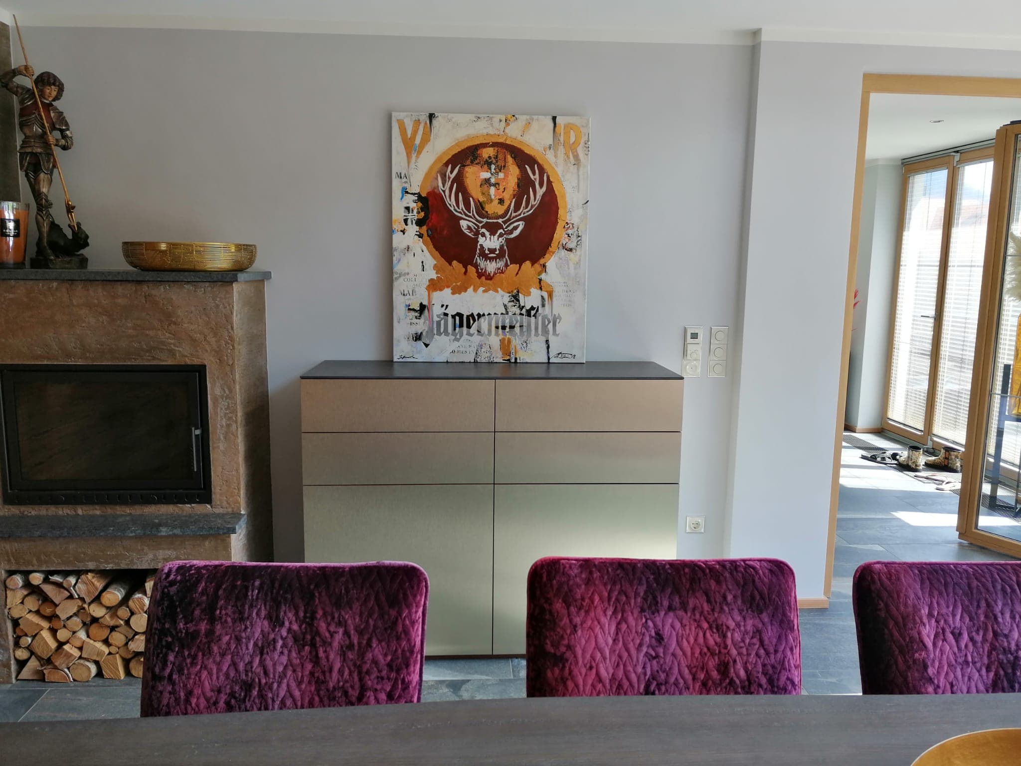 Sideboard mit Goldfinish neben dem Kamin